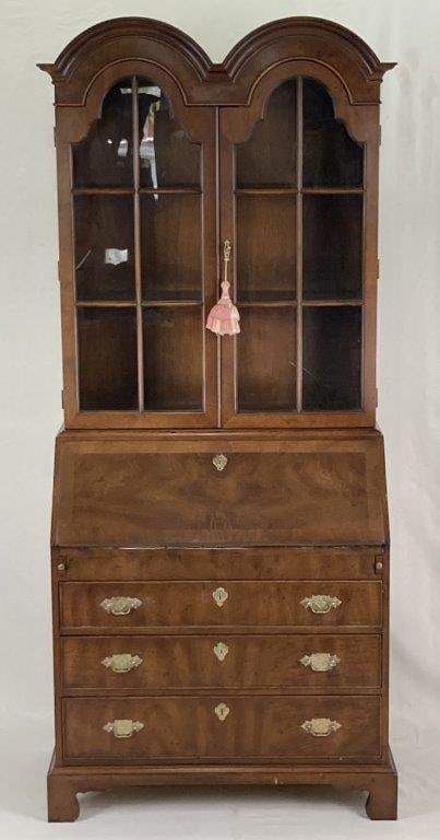 20th Century Mahogany Desk and Bookcase: A fine 20th century mahogany desk and bookcase featuring an attractive double dome top bookcase section above a slant-top desk. The desk opens to reveal multiple cubbies and two drawers on either side