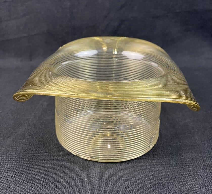 American Art Glass Top Hat: A charming American glass hat is an appealing novelty piece,Crafted from a soft yellow glass, the piece showcases a classic, whimsical shape. Measuring approximately 4 in. H x 8 in. in diameter, the