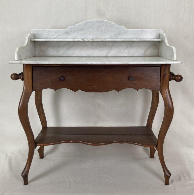 19th Century Mahogany Marble Top Washstand: A 19th century mahogany marble top washstand featuring a shaped drawer and shelf. It measures approximately 37 inches high x 35 inches wide x 18 inches deep. In good condition.
