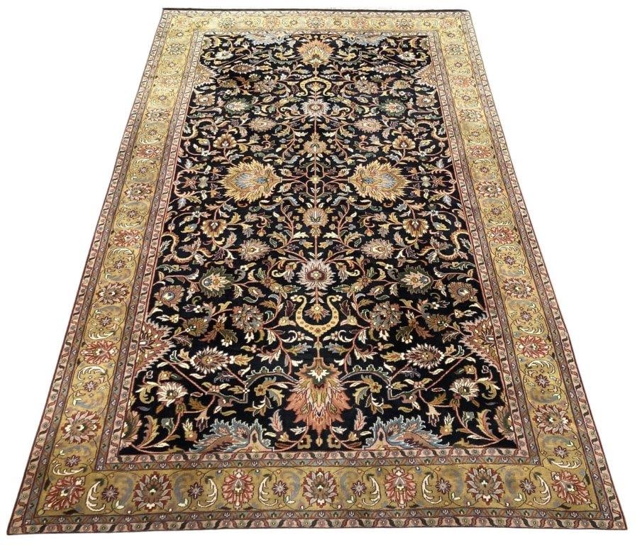 Palace Size Hand Knotted Rug: A late 20th century palace size hand knotted rug with thick wool pile. The rectangular black field is woven with an all-over design of stylized flowering vines, palmettes, and foliate motifs in tones