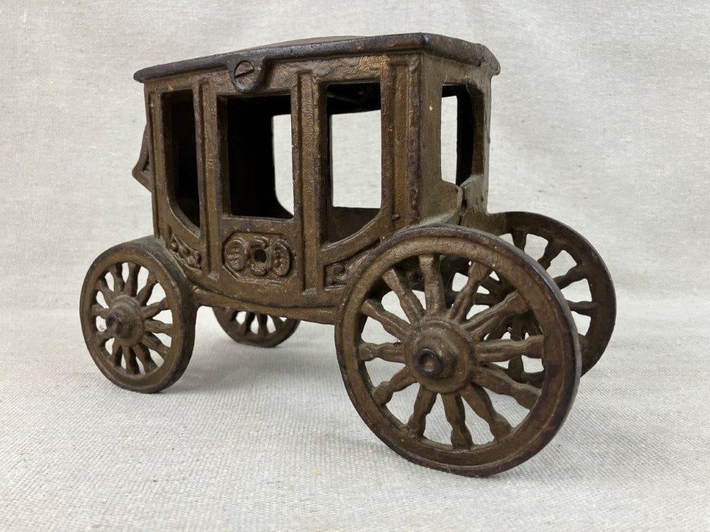 Cast Iron Carriage Doorstop: A cast iron carriage doorstop of attractive form, featuring a detailed carriage design with a wonderful aged patina and retaining nice remnants of original gold paint. It measures approximately 6