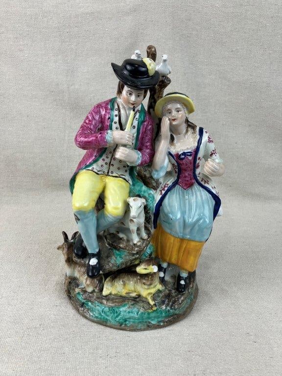 Staffordshire Pastoral Courting Couple Figurine: Figurine exemplifies classic hand-painted Staffordshire artistry, beautifully capturing a romantic courting couple in idyllic pastoral attire. The woman is gracefully modeled wearing a wide-brimmed