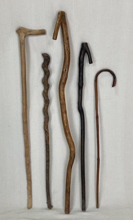 Group of Five Organic Farm Walking Sticks and Canes: A group of five walking sticks and canes, some featuring attractively twisted shafts and decorative elements. The group displays a variety of traditional folk art forms and turned details. The