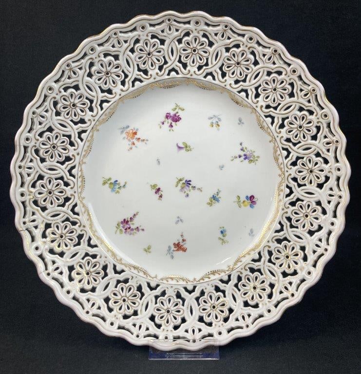 Dresden Hand-Painted Porcelain Plate: This Dresden porcelain plate features a stunning reticulated floral border accented by elegant gilt decoration, surrounding a central arrangement of finely detailed, hand-painted floral designs. Marke