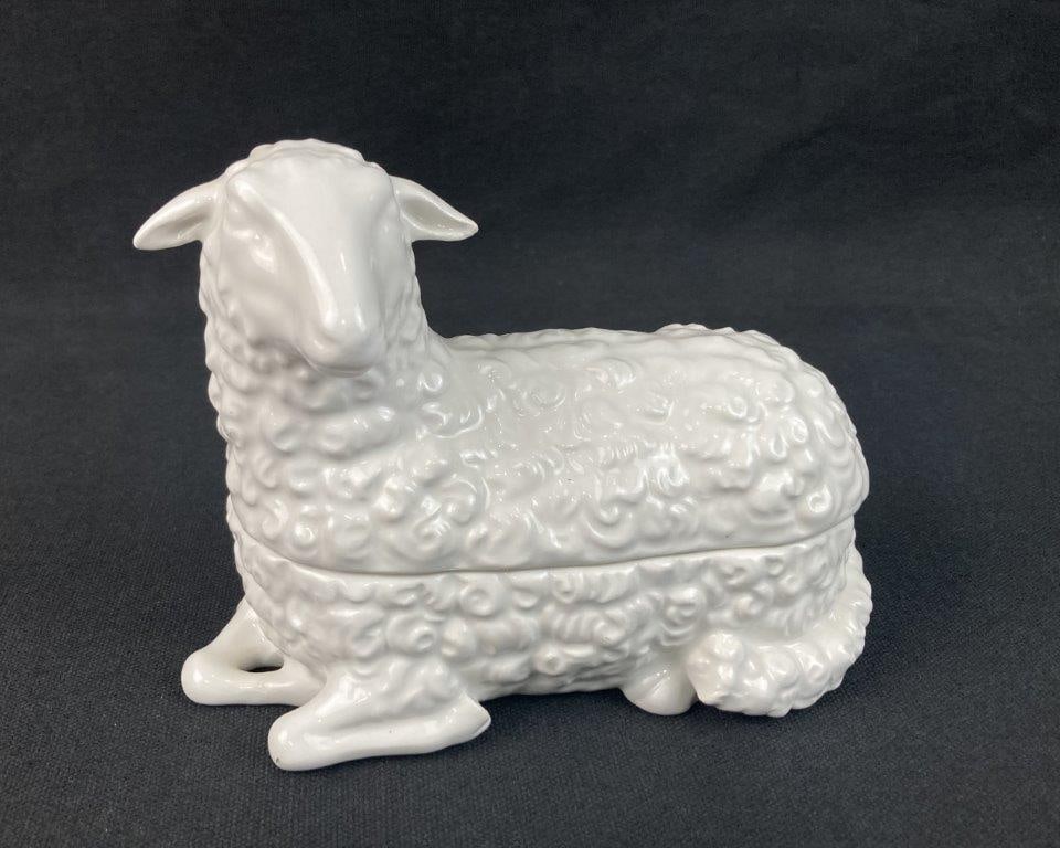 Mottahedeh Porcelain Sheep Trinket Box: This Italian-made Mottahedeh trinket box features a charming sheep form rendered in pristine white porcelain tones. The piece measures approximately 4 3/8 in. H x 2 1/4 in. W x 5 in. D and remains in