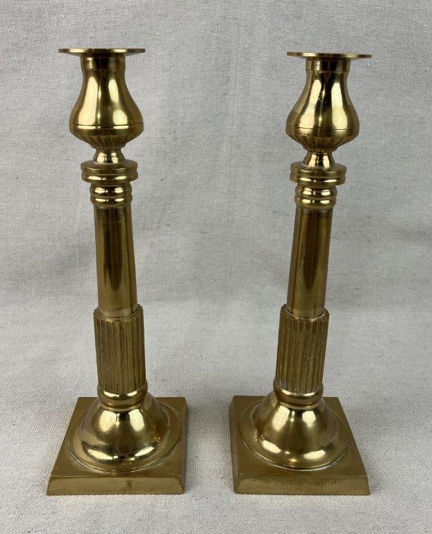 Pair of Neoclassical Style Brass Candlesticks: This elegant pair of Neoclassical-style candlesticks features a timeless columnar fluted design, beautifully capturing the architectural symmetry and refined sophistication of classical antiquity.