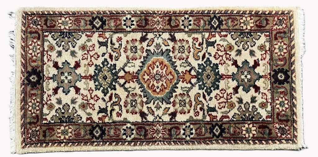 Hand Knotted Rug: A hand knotted rug with organic coloration featuring floral medallions on an ivory field. It measures approximately 25 inches x 48 inches. Some slight discoloration consistent with age and use.
