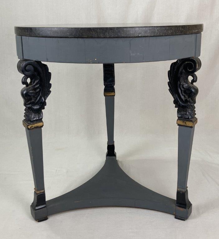 Neoclassical Granite Top Center Table: A 20th century neoclassical painted center table featuring a fine black granite top supported by carved griffin motifs resting on tapered legs. The piece exhibits strong neoclassical influence with