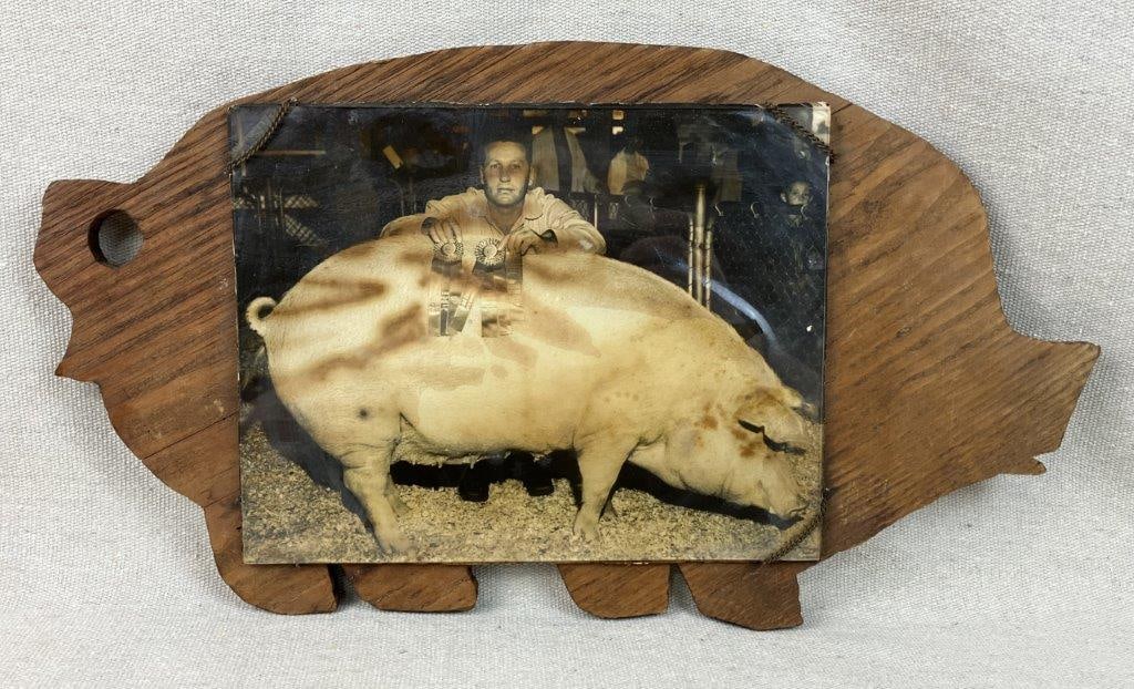 Prize Pig Folk Art Photograph and Cutting Board: Unique piece of Americana features an authentic vintage photograph creatively set under glass and expertly mounted onto a wooden cutting board carved into a whimsical pig silhouette. The captivating