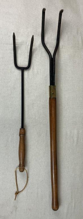 Two Wrought Iron Fireplace Tools: Substantial set of wrought iron fireplace tools showcases robust, timeless craftsmanship, making it both a highly functional and decorative addition to any traditional hearth setting. Featuring a