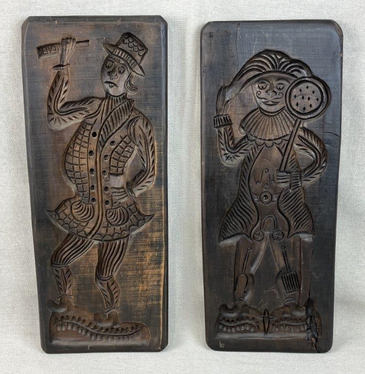 Pair of Carved Figural Dutch-Style Wall Plaques: This charming pair of hand-carved wood wall plaques beautifully captures a whimsical European aesthetic, featuring figures styled in traditional Dutch attire and playful poses. Each panel depicts an