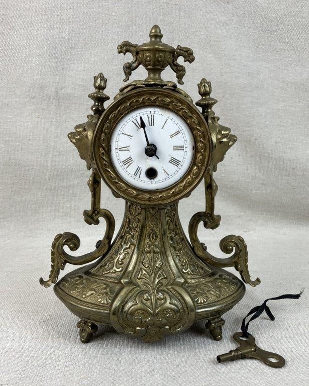 French Brass Ormolu Mantel Clock: This striking French brass ormolu mantel clock is beautifully designed in the ornate Louis XV style, showcasing intricate decorative scrollwork throughout its sophisticated form. The timepiece