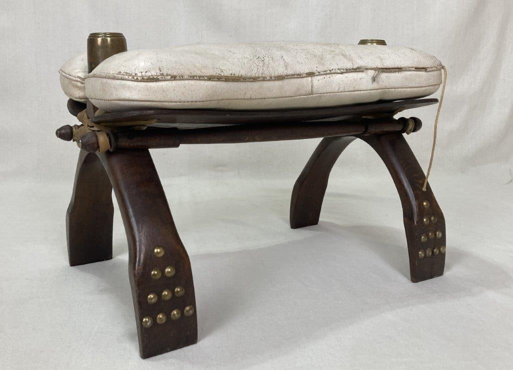 Moroccan Leather Camel Saddle Footstool: A Moroccan leather camel saddle converted into a wonderful footstool, featuring a white leather seat on exotic wood with brass tack decoration. It measures approximately 13 inches high x 12 inches wid