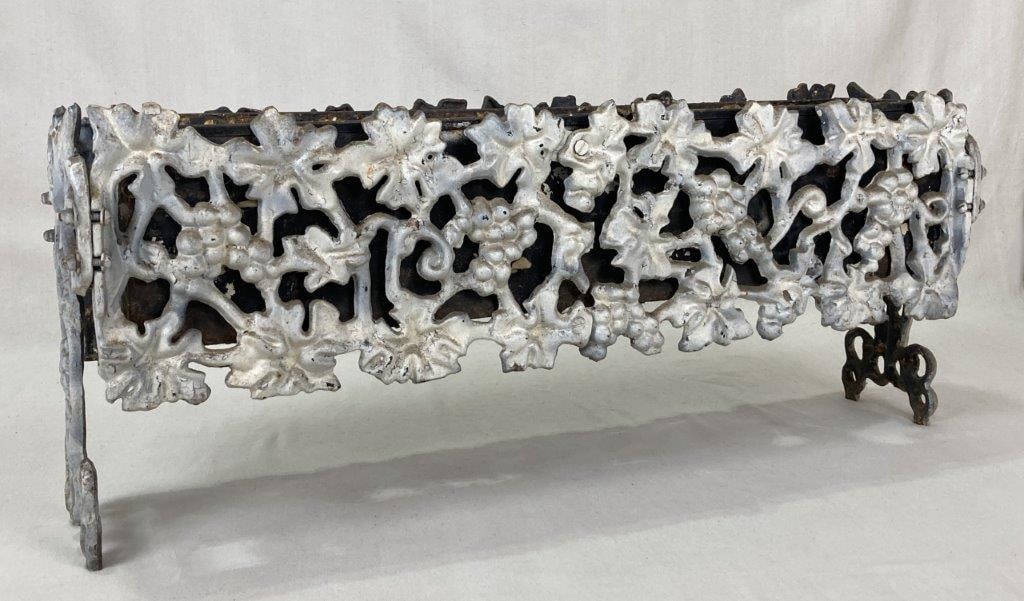 Ornate Cast Iron Planter: This footed, rectangular cast iron planter features an intricate open-work motif of grapevines and detailed leaves. The piece exhibits a unique dual-color finish, with one side painted white and the