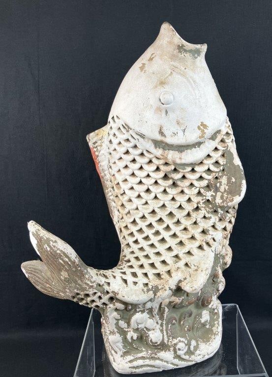 Japanese Carp Lawn Ornament: This striking plaster sculpture captures a Japanese carp, often referred to as a koi fish, caught in dynamic motion above a watery base defined by expressive, sculpted waves. Possessing a commanding