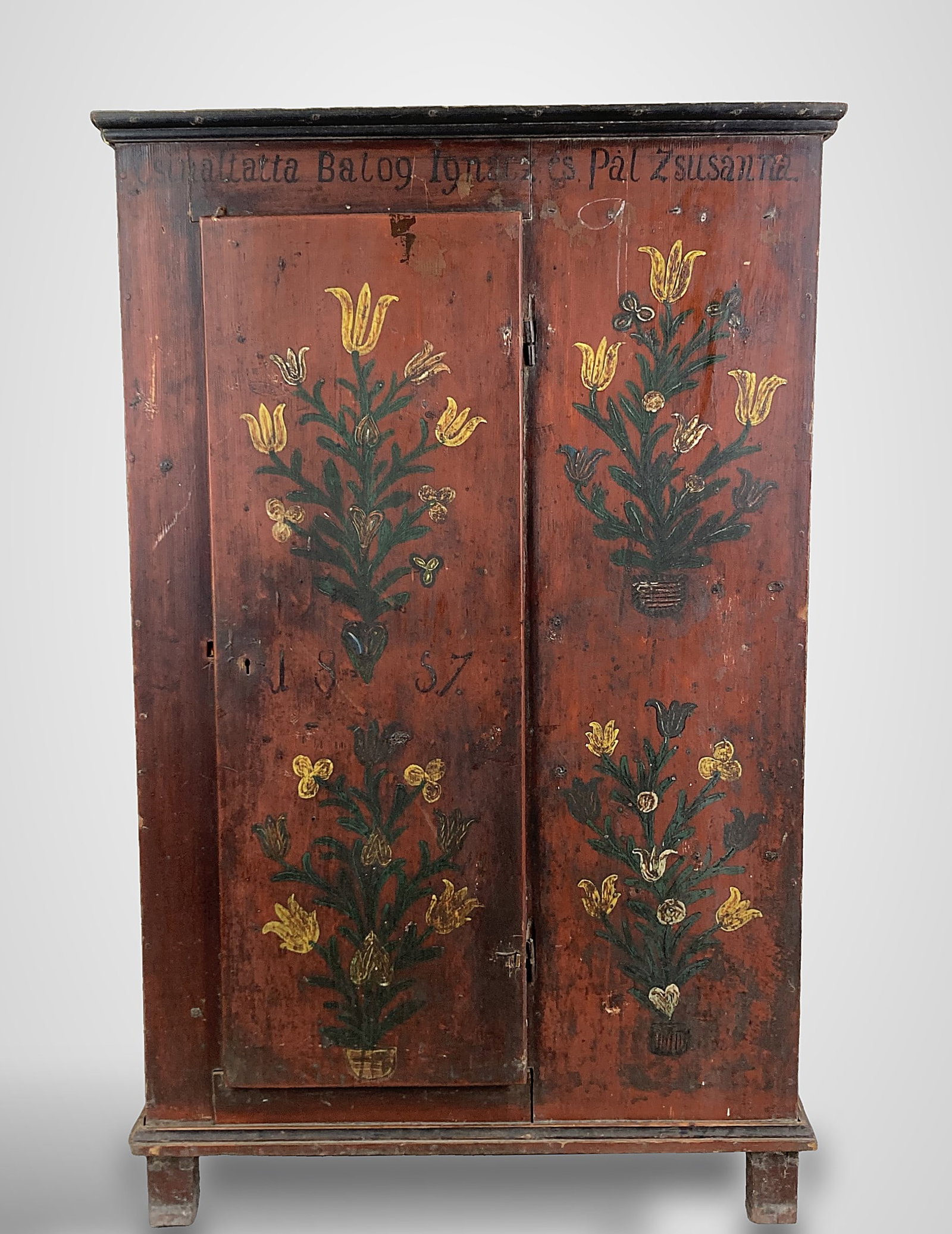 Dated 1857 Continental Folk Painted Cupboard: An exceptional mid-19th century Hungarian folk painted pine wardrobe, dated 1857, retaining its original red painted surface with vibrant hand painted floral decoration throughout, the single-door cab