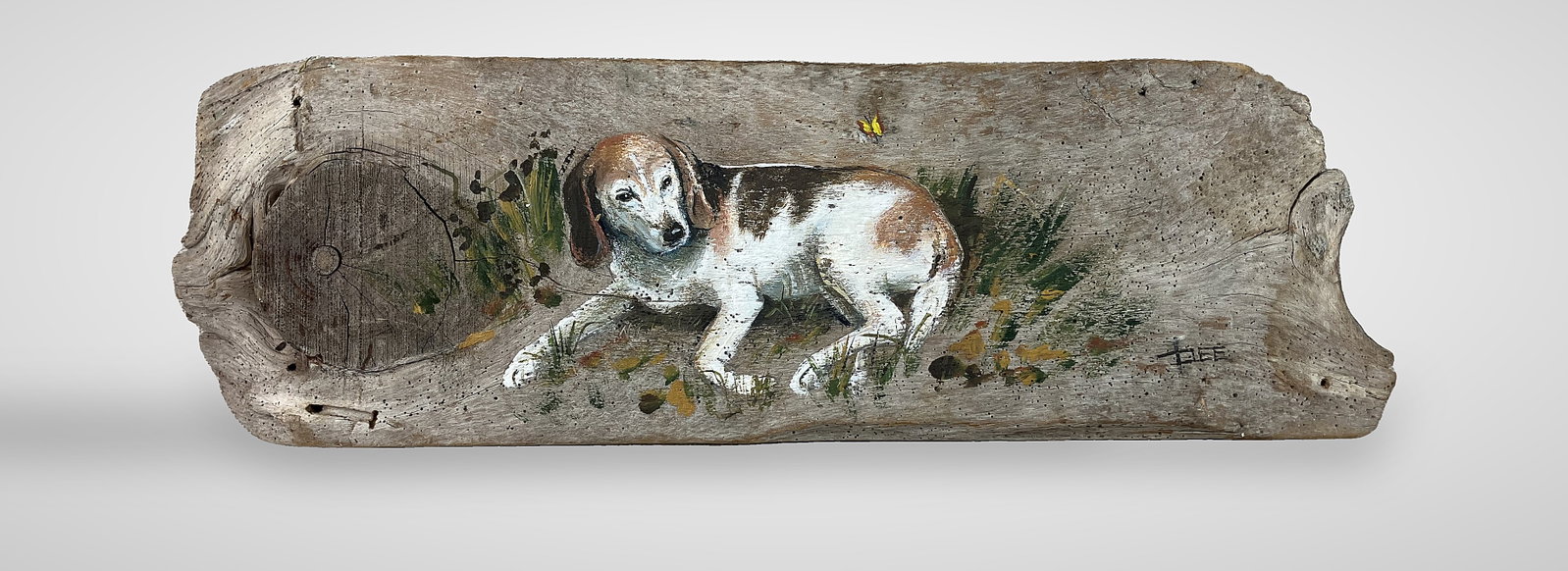 Folk Art, Hound Dog Painting on Driftwood: Charming folk art piece, signed Dee, features a scene of a beagle resting leisurely on grass with a nearby butterfly. Expertly executed on a piece of weathered driftwood, the work highlights a strong
