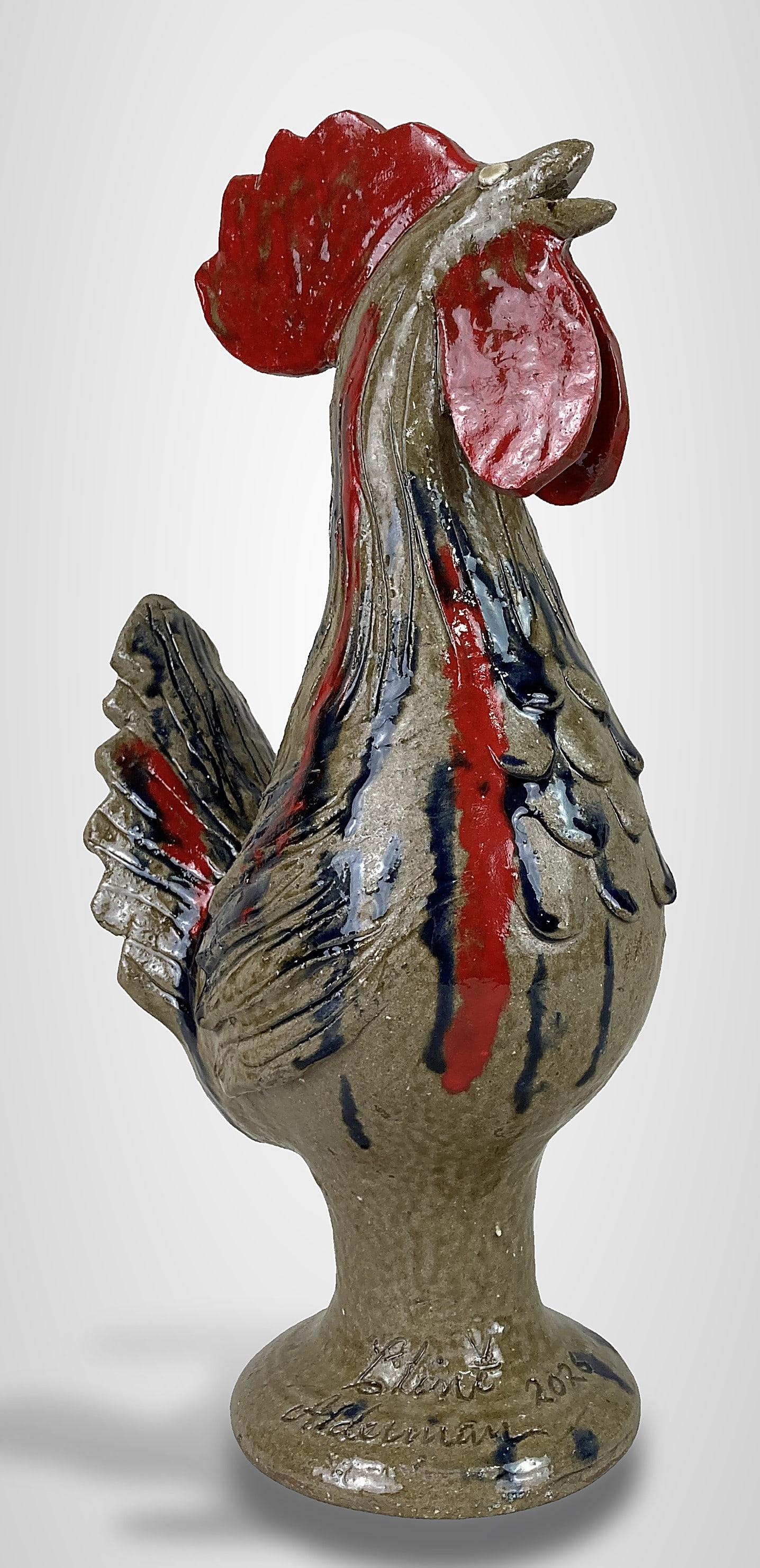 Clint Alderman Southern Pottery Rooster: This hand-sculpted pottery rooster was created by Georgia folk potter Clint Alderman. It features a bright red glazed comb and wattle, which contrast with dark blue and red streaks on the stoneware li