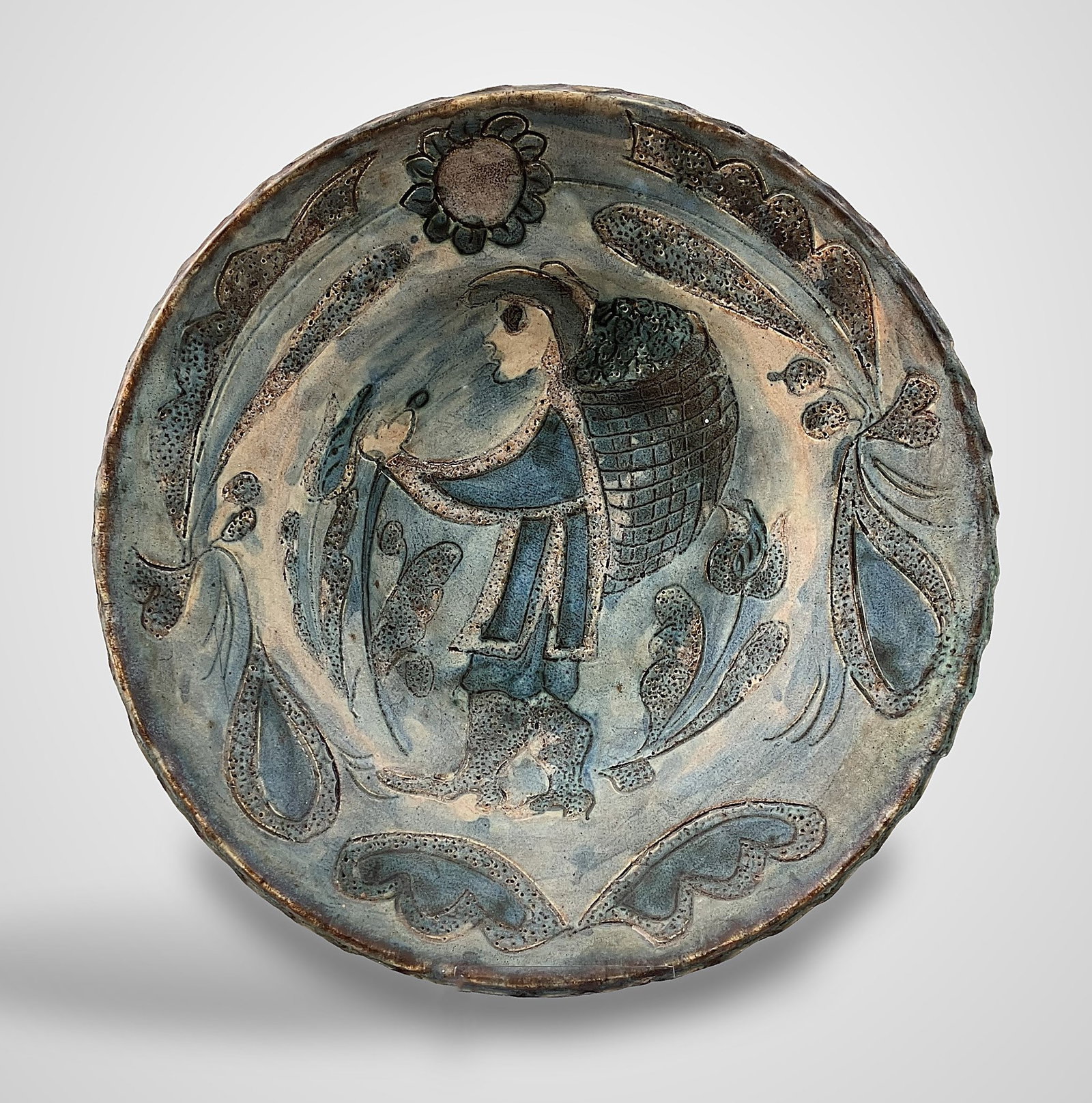 Francoise Chedeville French Ceramic Bowl: Piece features slip-carved (sgraffito) decoration depicting a central figure carrying a basket, framed by a vegetal border in an appealing modernist style. The bowl is signed with an incised