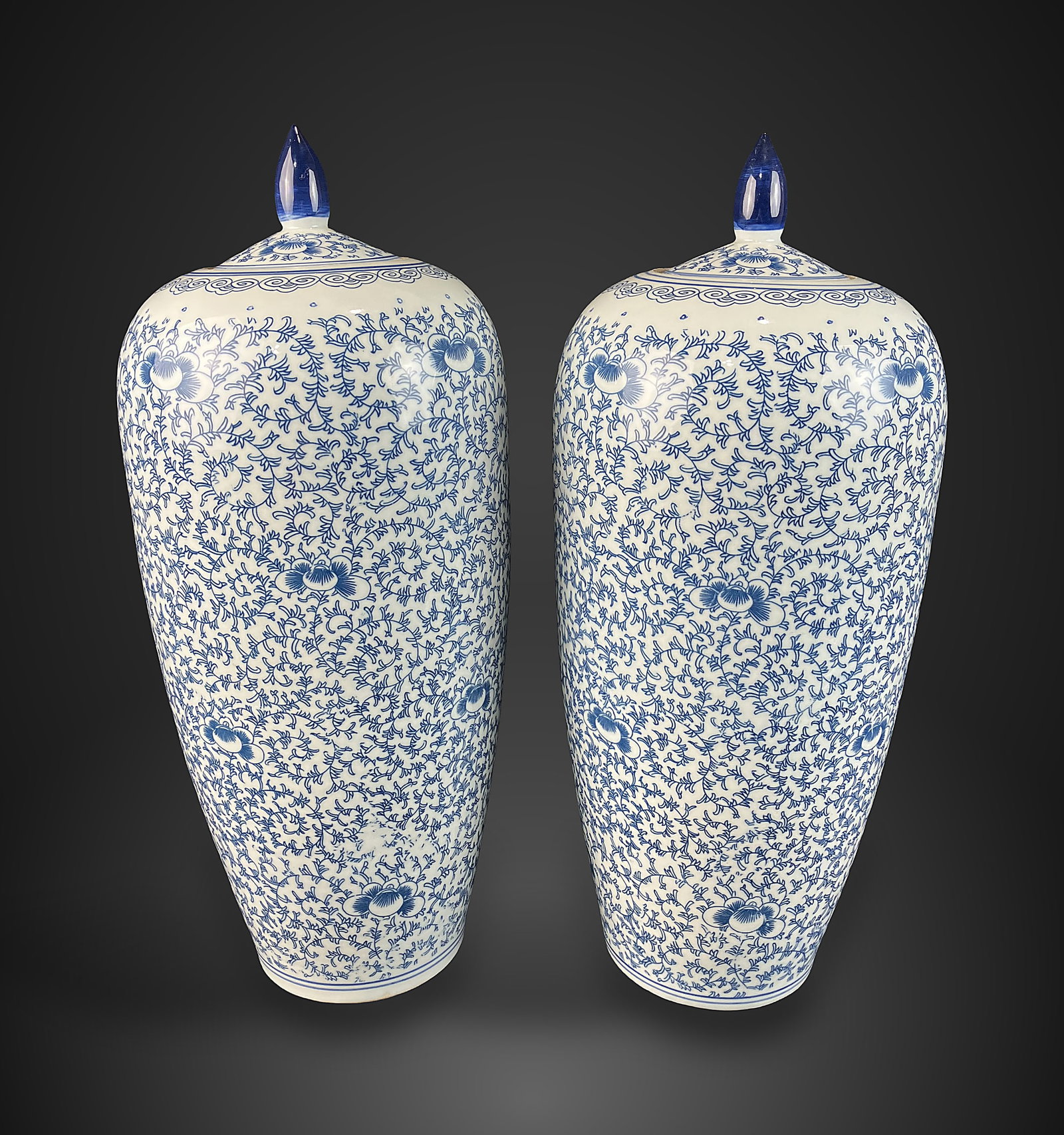 Pair of Chinoiserie Blue and White Ginger Jars: Pair of large porcelain ginger jars features an elegant, vase-like curving silhouette adorned with classic blue and white motifs. Each jar measures approximately 19 1/2 in. H x 8 in. in diameter and