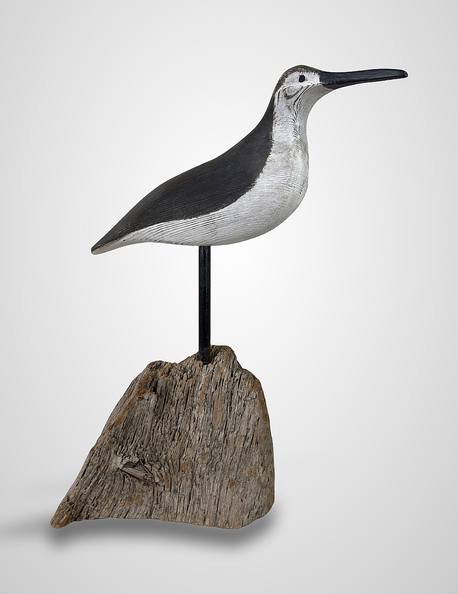 Polychromed Folk Art Shorebird Sculpture: This hand-carved and hand-painted wooden shorebird decoy features a smooth, whittled body with a striking two-tone color scheme of dark gray on the upper body and a white underbelly. The sculpture is