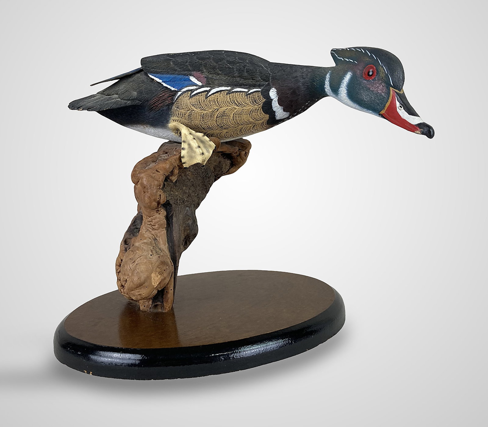 William Veasey Wood Duck Sculpture: This hand-carved sculpture by renowned artist William Veasey (1932â€“2022) captures a male Wood Duck Drake in a dynamic landing pose. The figure features intricate hand-painted