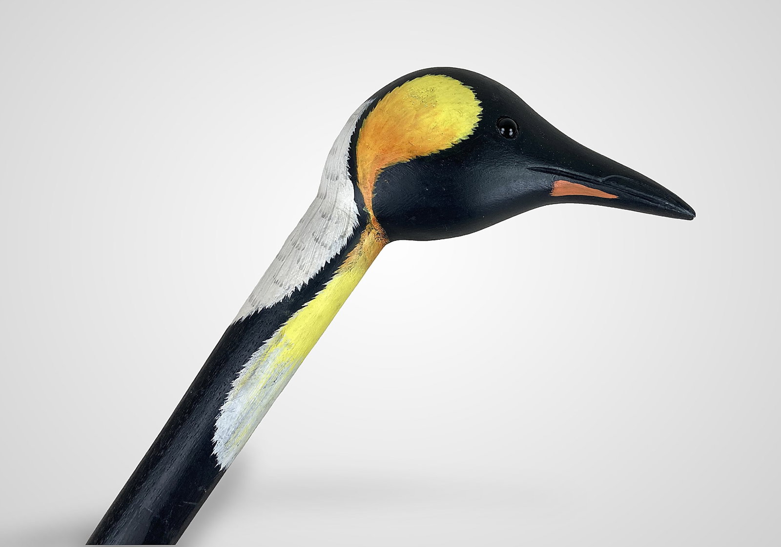 Folk Art Carved Penguin Cane: This hand-carved and painted cane features an ergonomic handle shaped like a King Penguin's head, accented with hand-painted bright yellow and orange neck markings against a sleek black and white
