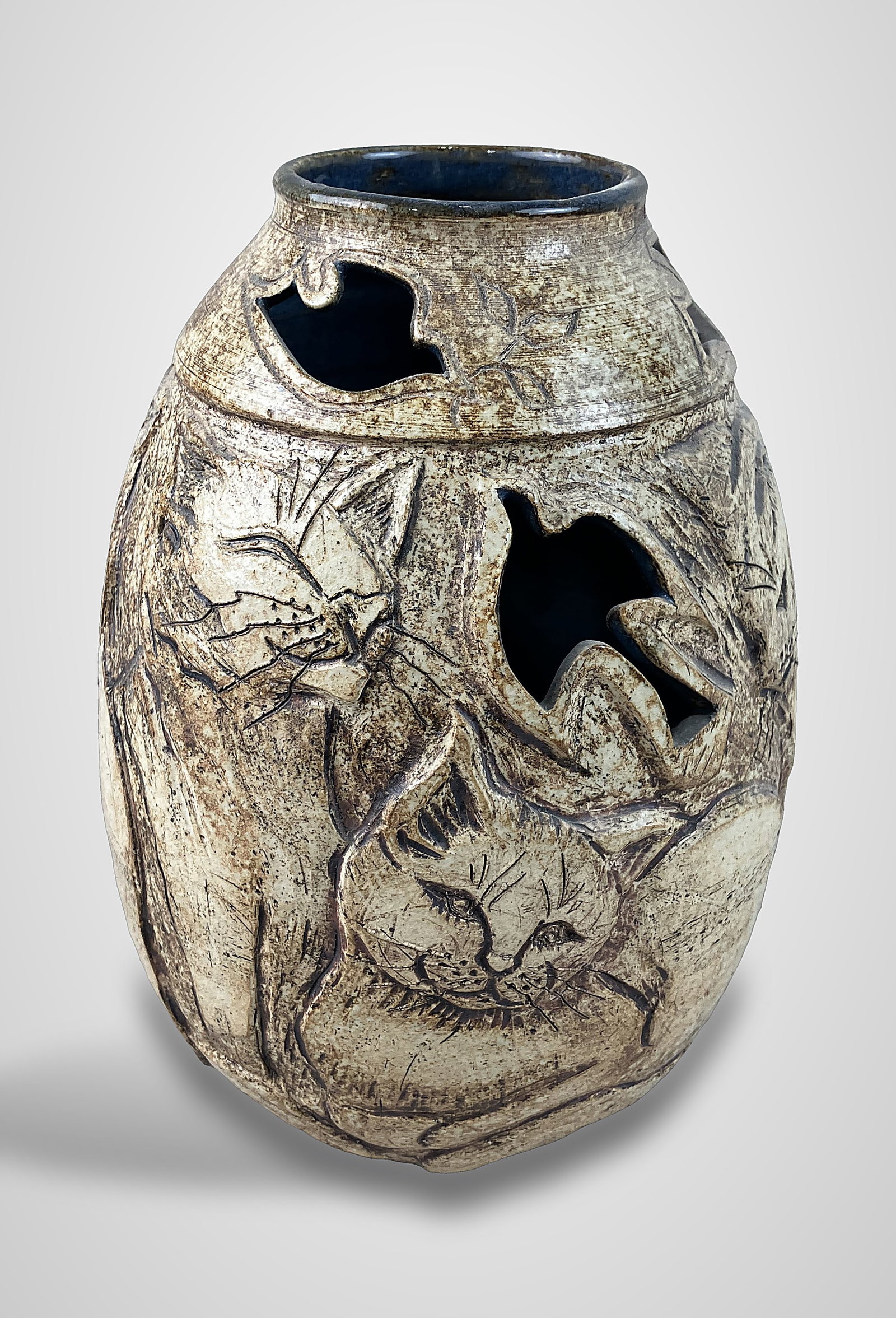 Studio Pottery Cat Vase: Piece features a relief cat design set against a creamy, speckled clay body, with sgraffito technique used to define the cats features. The vase incorporates reticulated work,dove form cutouts and is