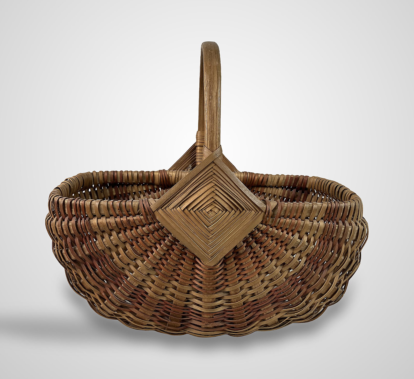Fine Country Woven Basket: This fine country basket features a wrapped rim and an attractive two-tone coloration with excellent detailing. It is designed with a convenient handle and measures approximately 15 in. H x 15 1/2