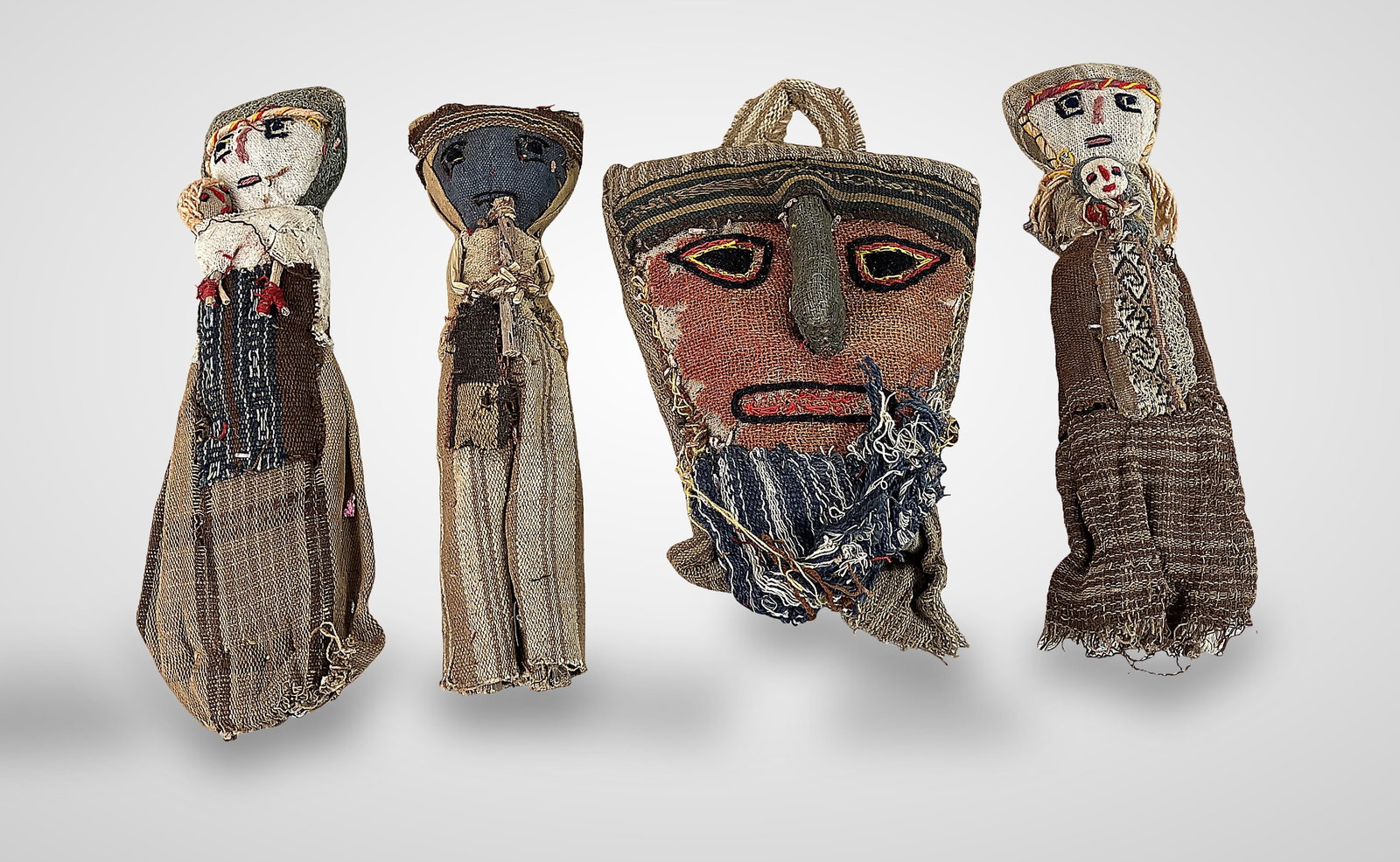 Peruvian Chancay Burial Dolls: Set of four handmade dolls features fabric bodies stuffed with reed or husk, reflecting the ancient tradition of placing such figures at burial sites. Dimensions for one approximately 10 1/2 in. H x