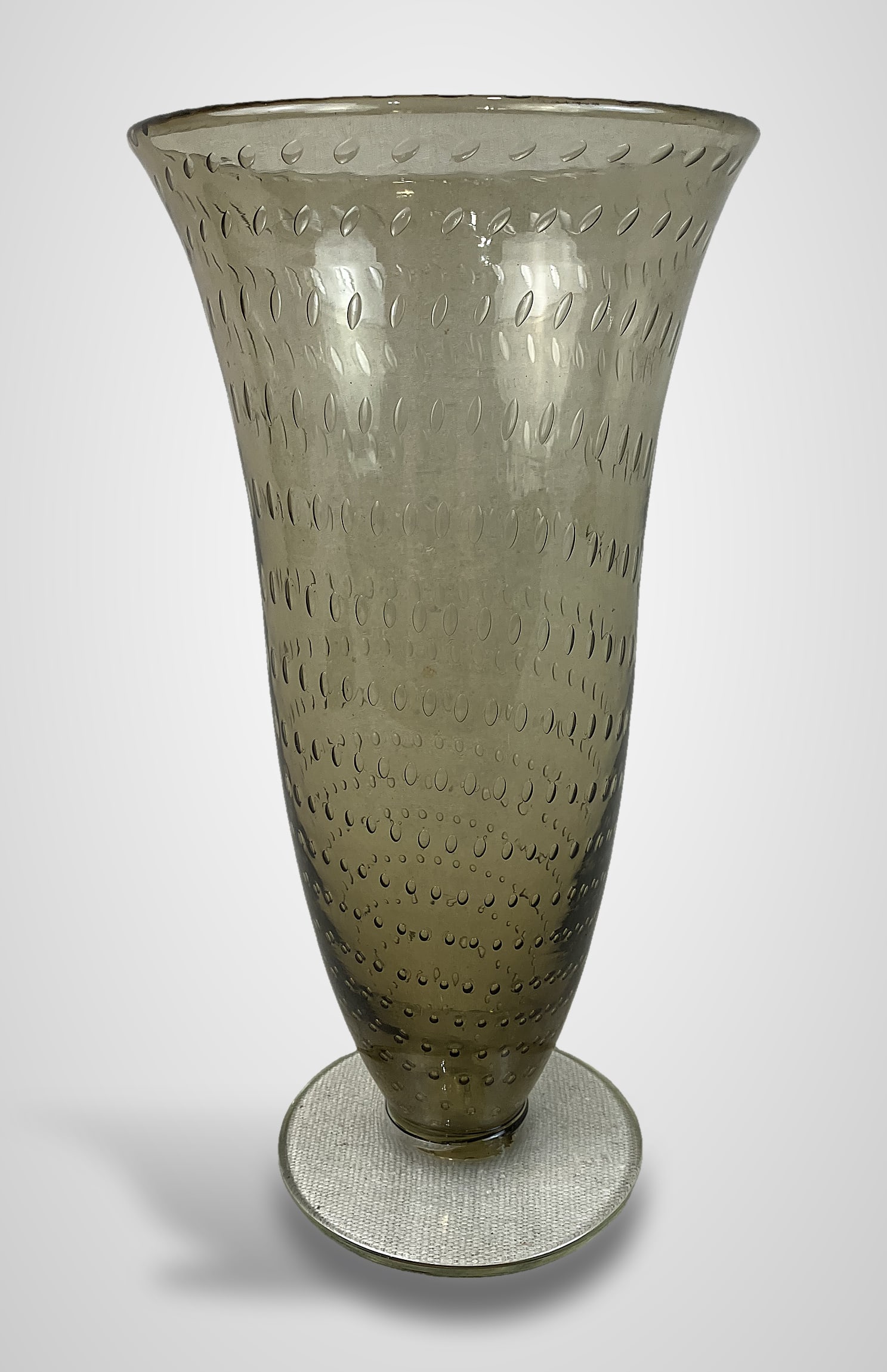 Mid-Century Modern Art Glass Vase: This footed vase features a curving form with a flared lip and is crafted using the bullicante technique, which creates a controlled pattern of air bubbles within the glass. The tones are similar to