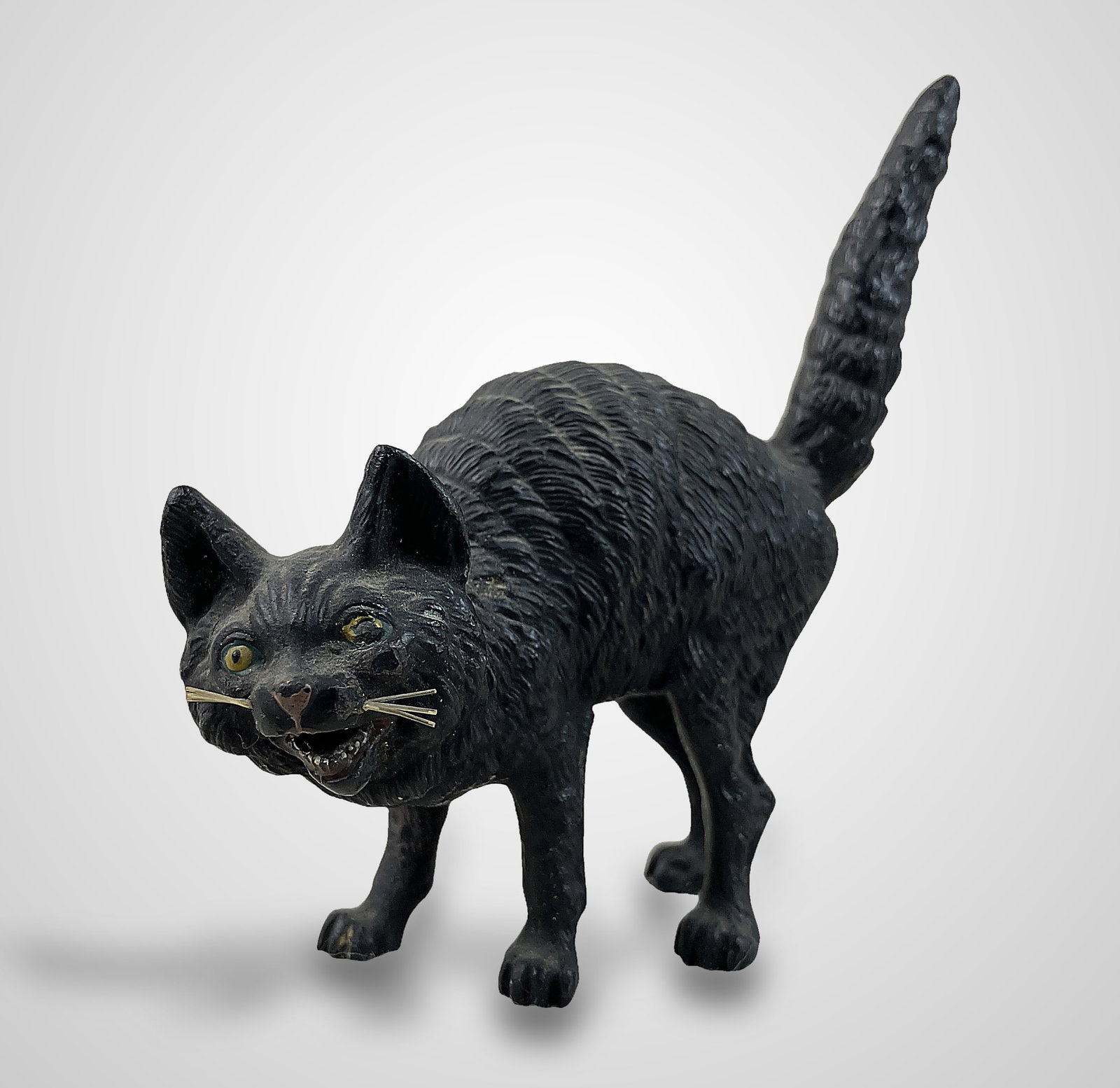 Austrian Cold Painted Bronze Cat: This piece, created in the Austrian taste of slightly larger miniatures, possesses engaging and lively features. The cat is depicted with an open mouth, wide eyes, standing fur, and an extended tail.