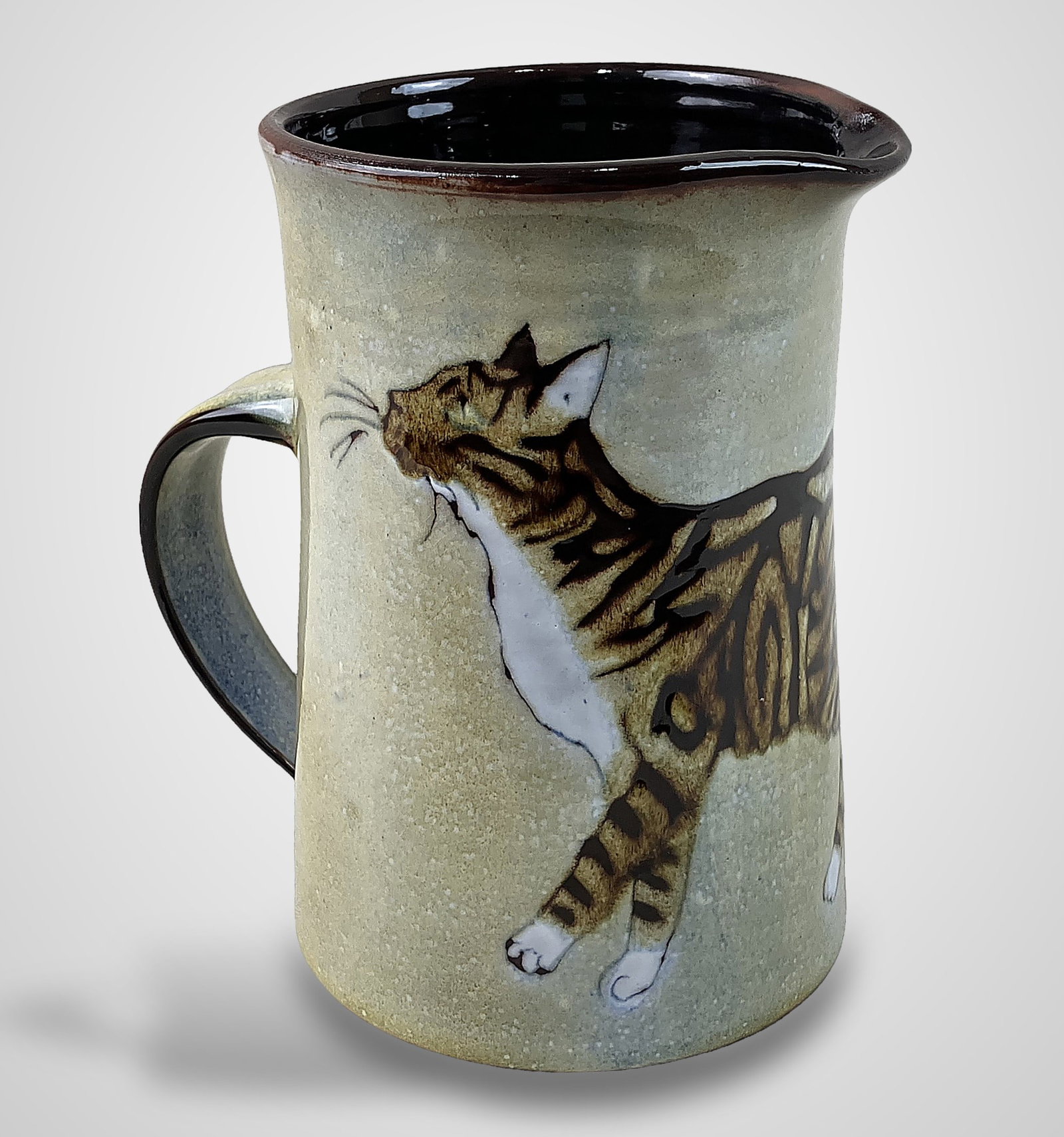 Chelsea Pottery Joyce Morgan Cat Pitcher: Piece of art pottery features a circumference decorated with charming brown tabby cats and is signed with a Chelsea label affixed to the base. It measures approximately 7 in. H x 5 3/4 in. in