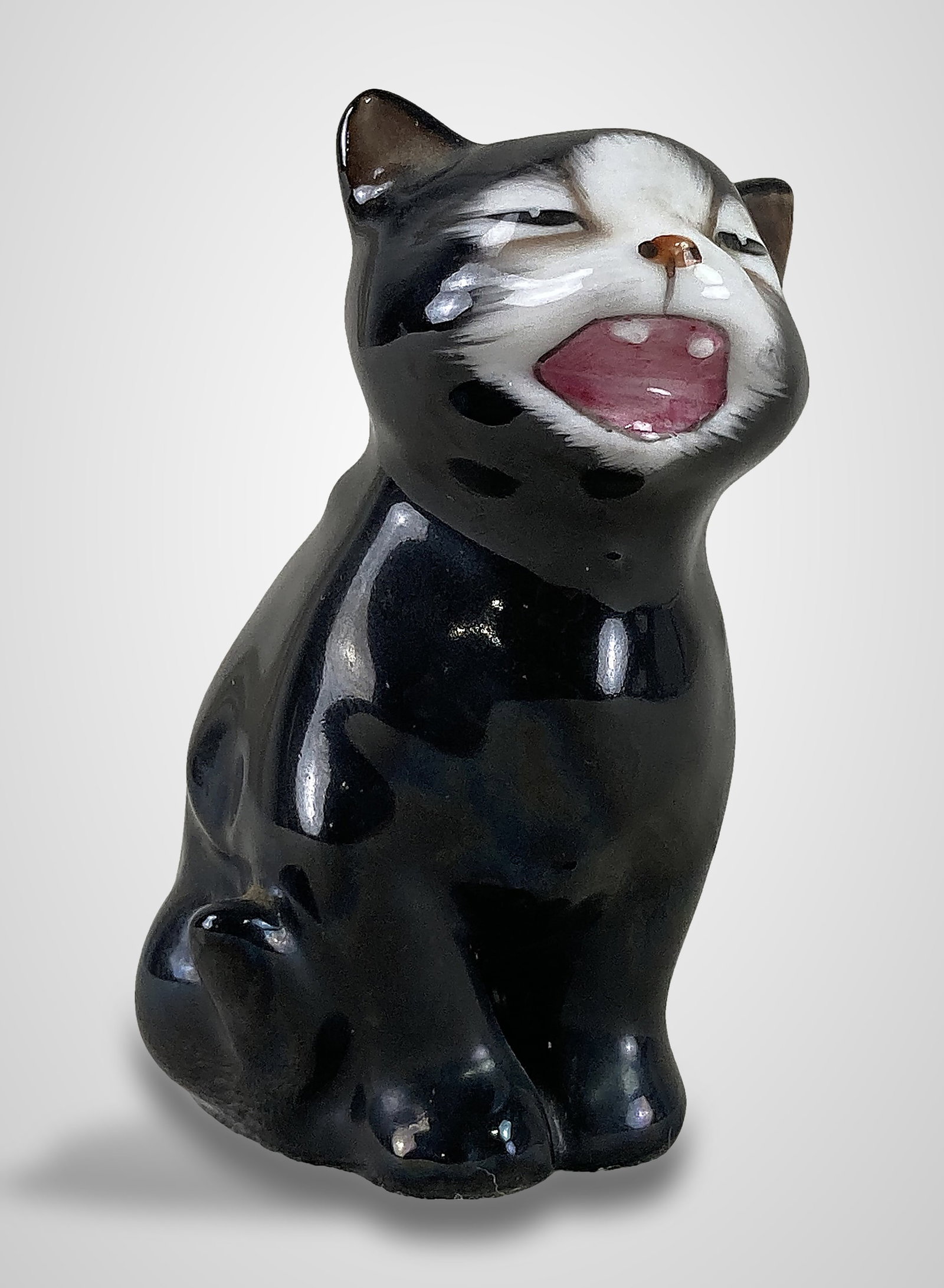Royal Doulton Lucky Cat Figure: Crafted from fine bone china, this hand-painted figure depicts a black cat with an expressive, open-mouthed look. It is identified as model number K12 and is titled "Lucky," with the maker's mark