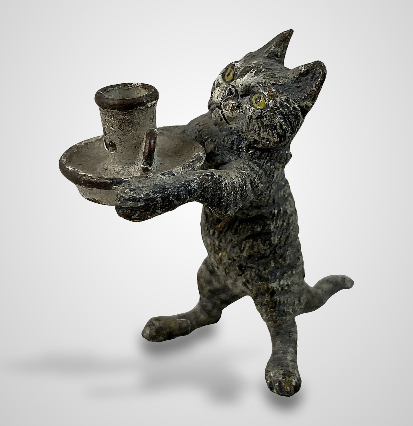 Cold Painted Bronze Cat Miniature: Charming miniature depicts a cat holding a teacup and saucer. Subtle hand-painted details enhance the texture of the fur. The piece measures approximately 1 1/2 in. H x 3/4 in. in diameter and shows