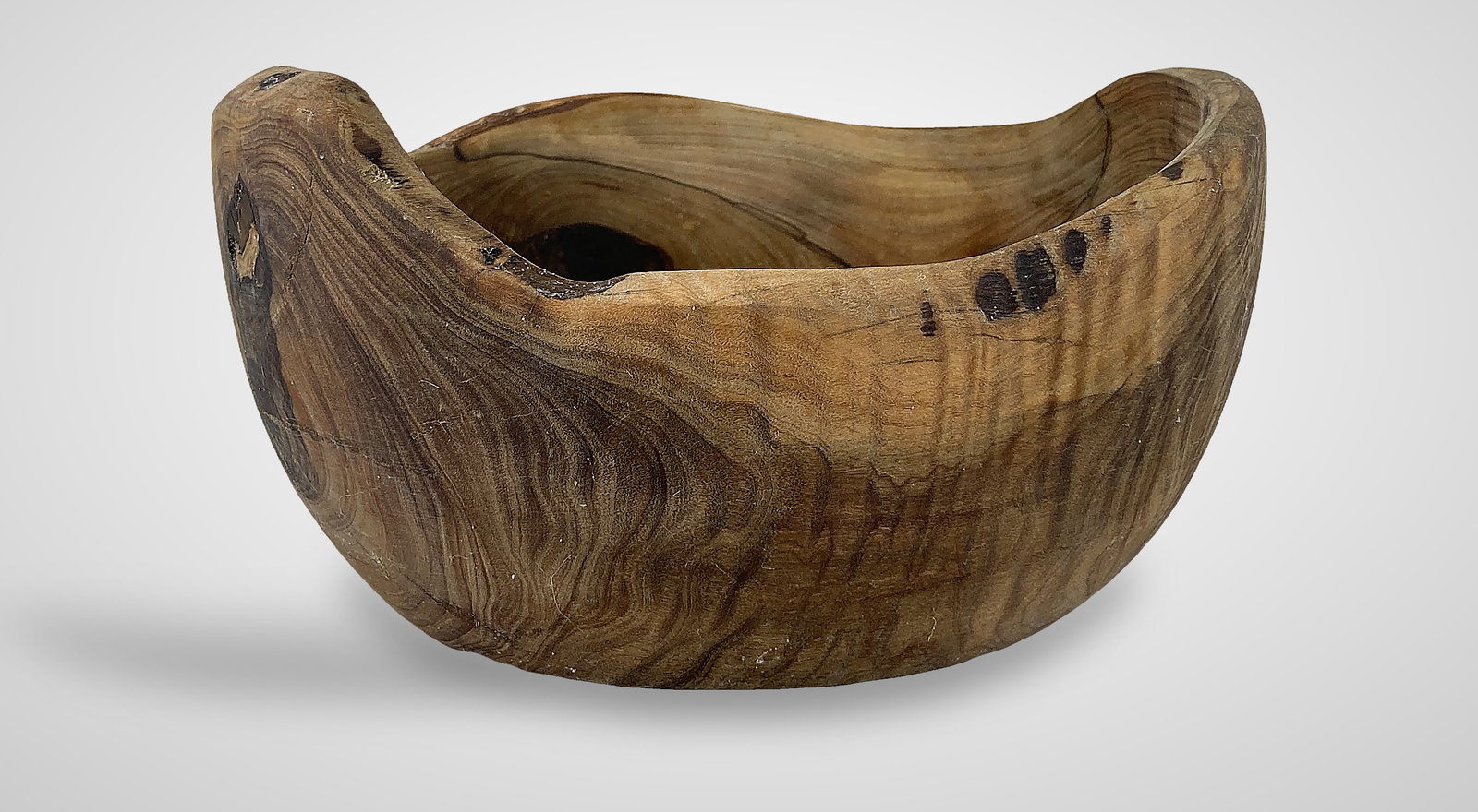 Live Edge Wood Bowl: This hand-crafted piece showcases a rich, swirling grain pattern ranging from light amber to deep brown tones. It features a natural live-edge profile and a warm, inviting patina. The bowl measures