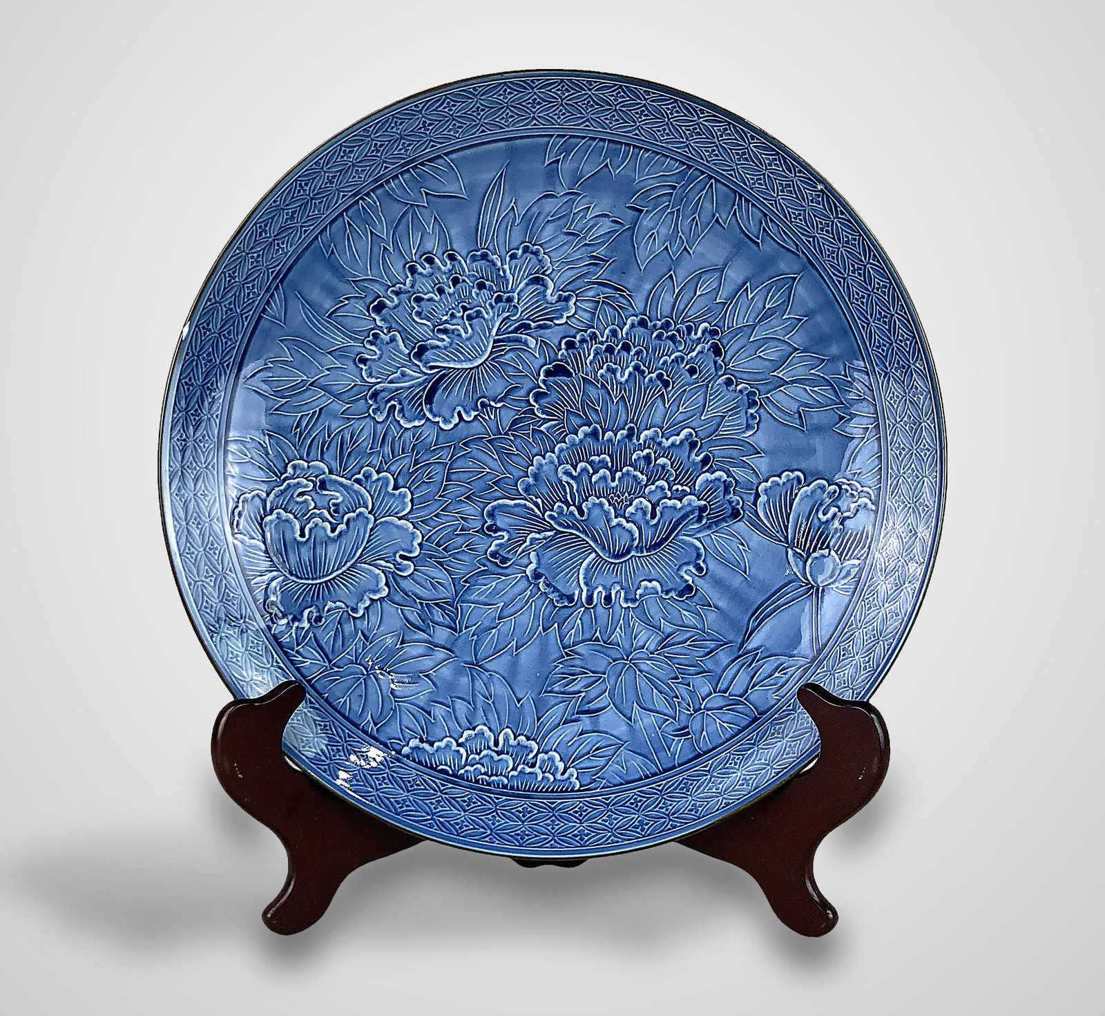 Arita-Hizen Japanese Porcelain Plate: Produced by the Hizen Tetsusaburo kiln during the Showa period, this plate features a rich, solid blue monochrome glaze. It is distinguished by a highly detailed, embossed Ukihori (raised relief)