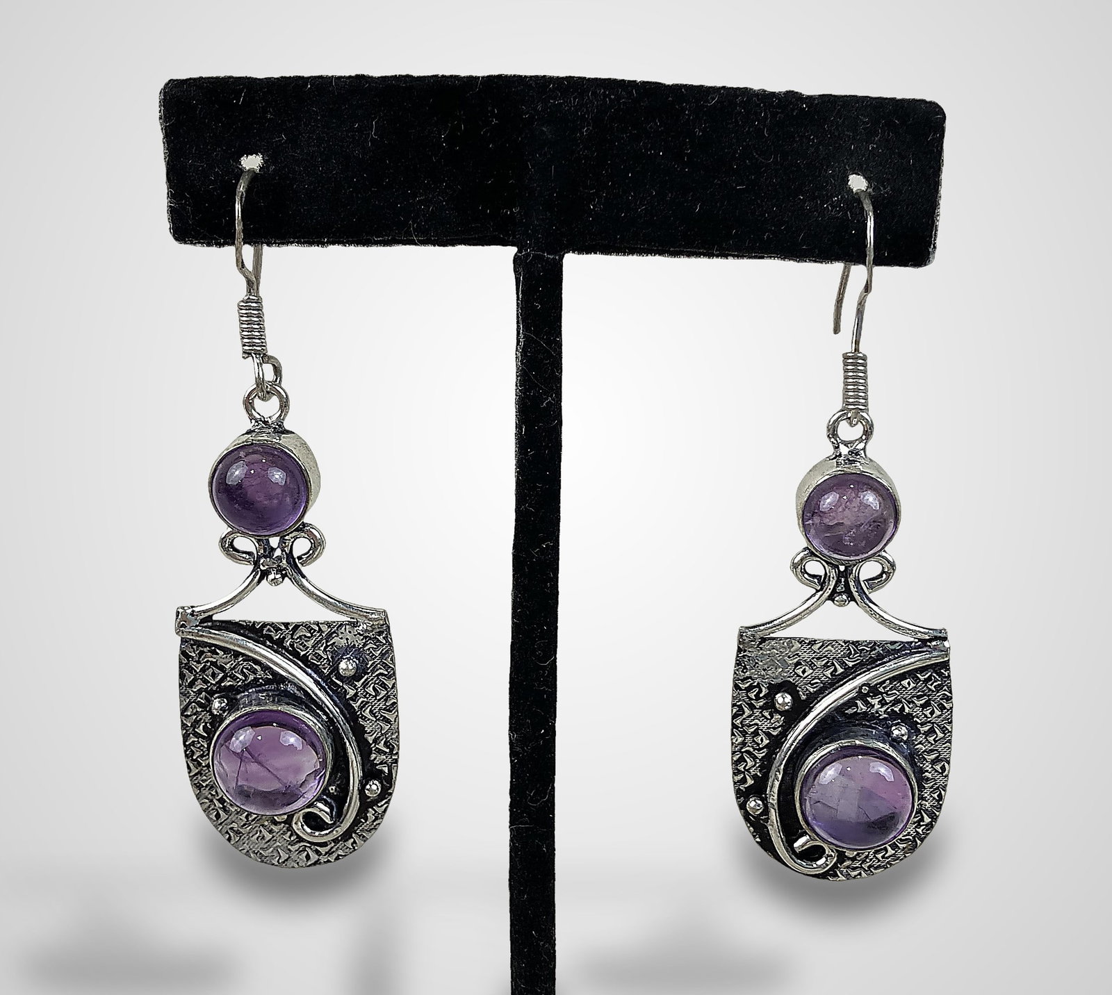 Sterling Silver Amethyst Earrings: Elegant modernist dangle earrings feature an artisan style with two amethyst cabochons set in each sterling silver frame. They measure approximately 1 7/8 in. H x 3/4 in. W and have a total weight of
