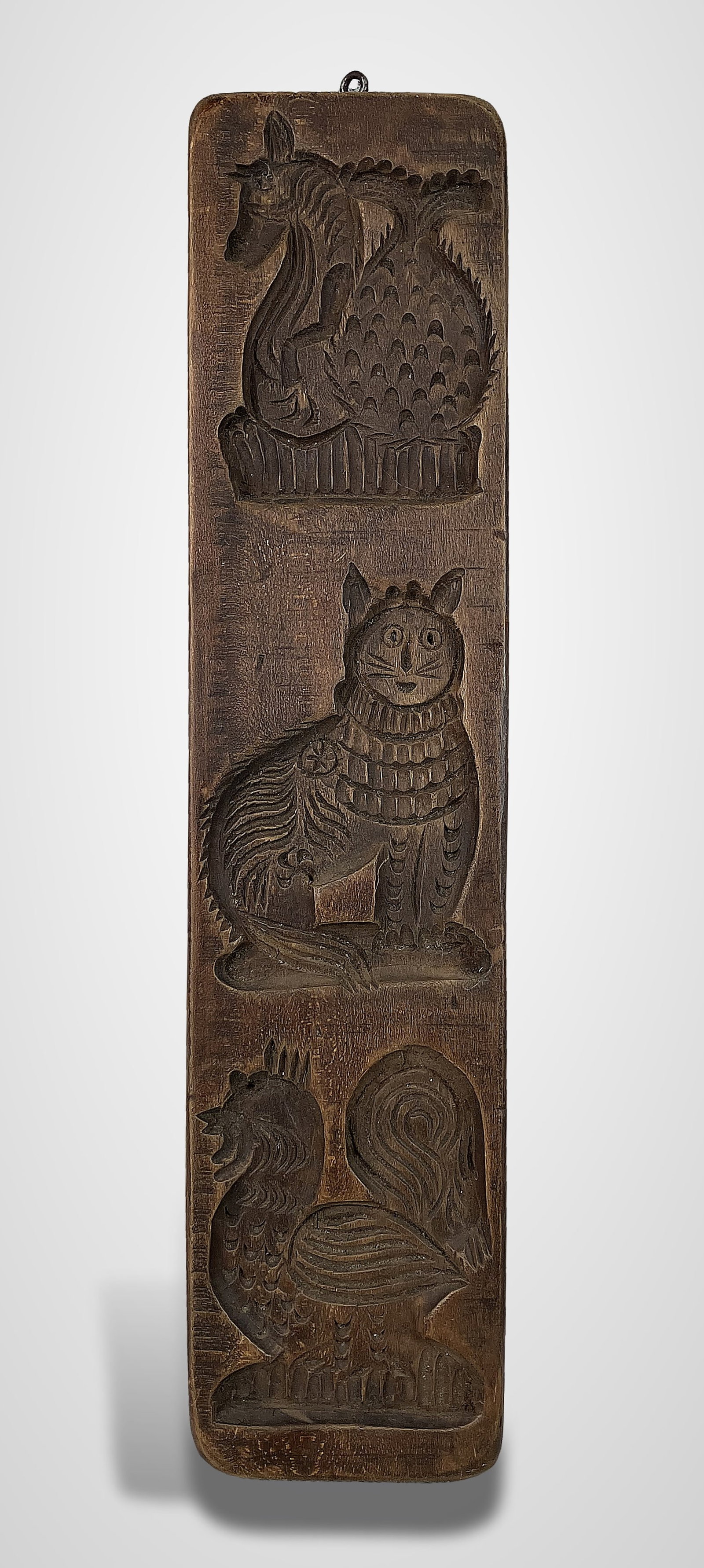 Folk Art Carved Wood Animal Wall Plaque: This vertical wall plaque features a series of three animals rendered in a subtractive carving style: a central cat, a rooster at the bottom, and an additional animal at the top. The piece exhibits a