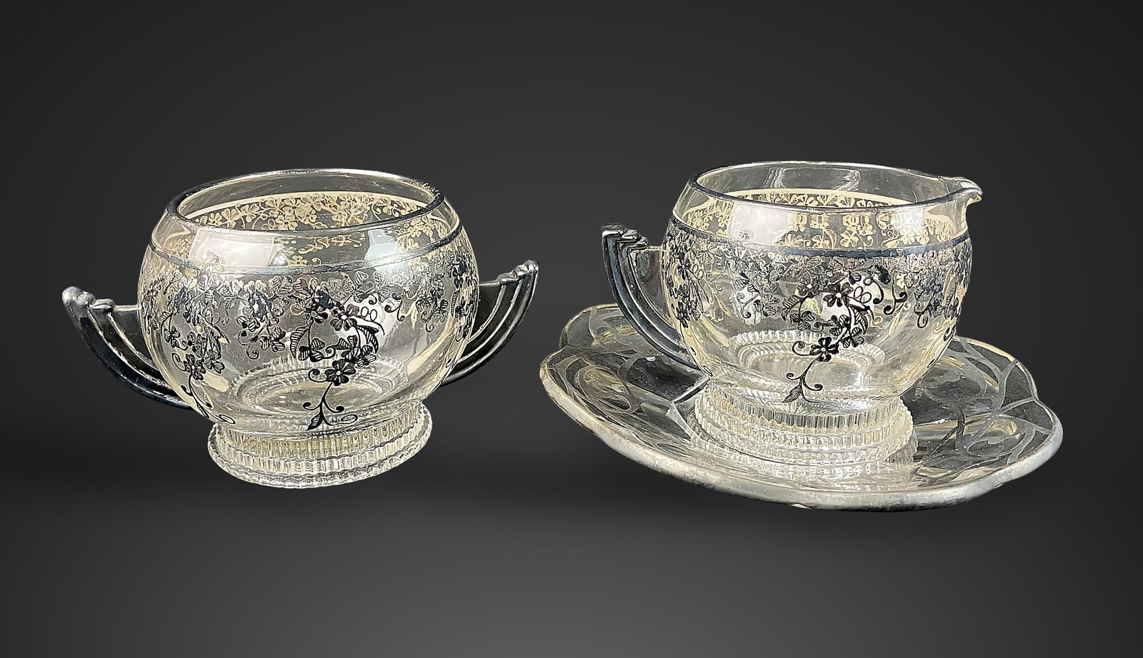 Art Deco Silver Overlay Glassware: Elegant three-piece set includes a footed open sugar bowl, and more. The collection is defined by classic Art Deco styling, featuring graceful, sweeping handles and intricate floral silver overlay