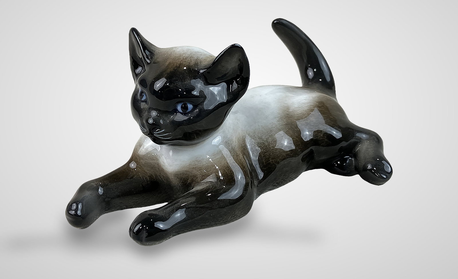 Rosenthal Siamese Kitten Figurine: This delightful Siamese kitten figurine Model 1907 was designed in the 1930s or 1940s by the celebrated German artist Fritz Heidenreich. The piece captures the kitten in a graceful laying pose,