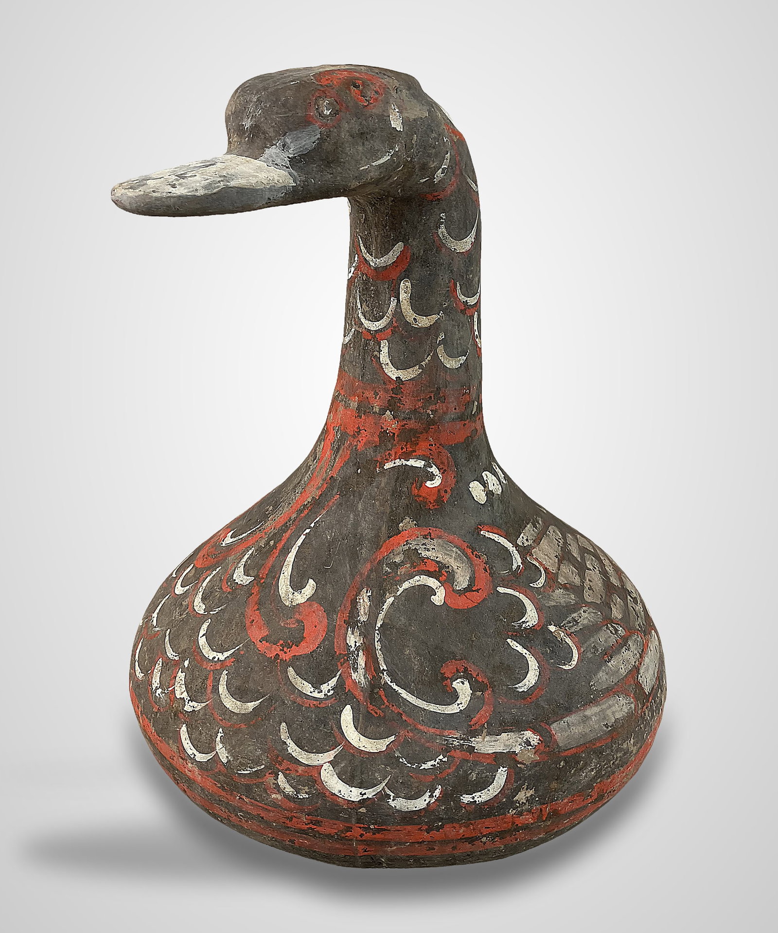 Chinese Funerary Pottery Duck: This earthenware vessel is designed in the likeness of a duck, inspired by early Han Dynasty funerary figures. It features intricate polychrome pigments applied in curving red and cream patterns to re