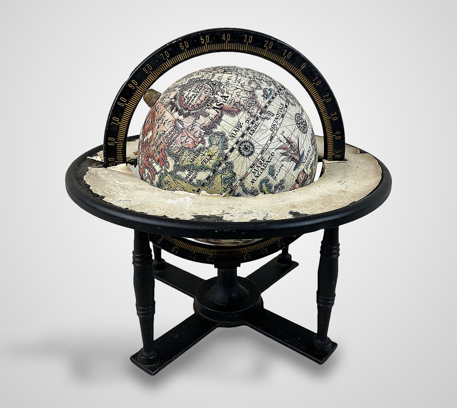 Tabletop Globe: Vintage tabletop globe features an early-style map design mounted in a metal stand. It measures approximately 8 in. H x 7 3/4 in. in diameter. The piece exhibits some wear to the paper mapping and