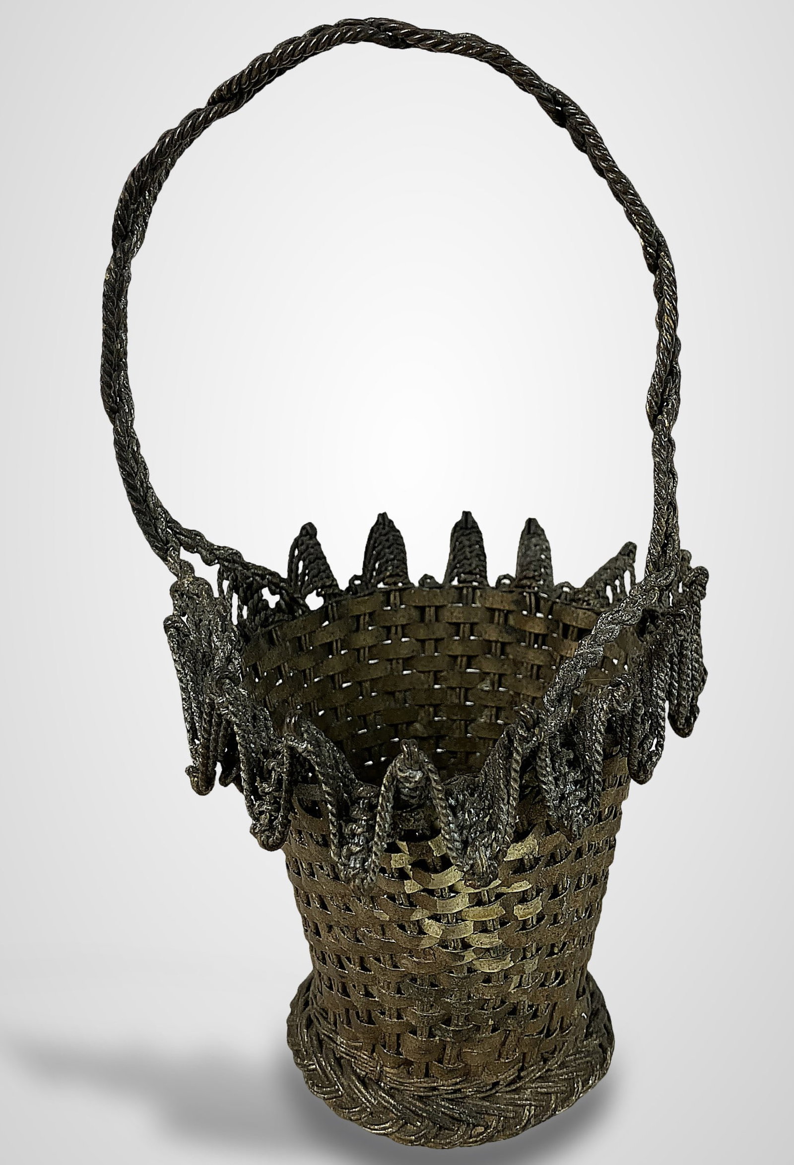 Mid-Century Modern Woven Metal Basket: Basket is tightly woven from wire strips and features a gilt-decorated finish, an ornate frilly border, and a coordinating handle. Measuring approximately 7 in. H x 3 in. in diameter, this