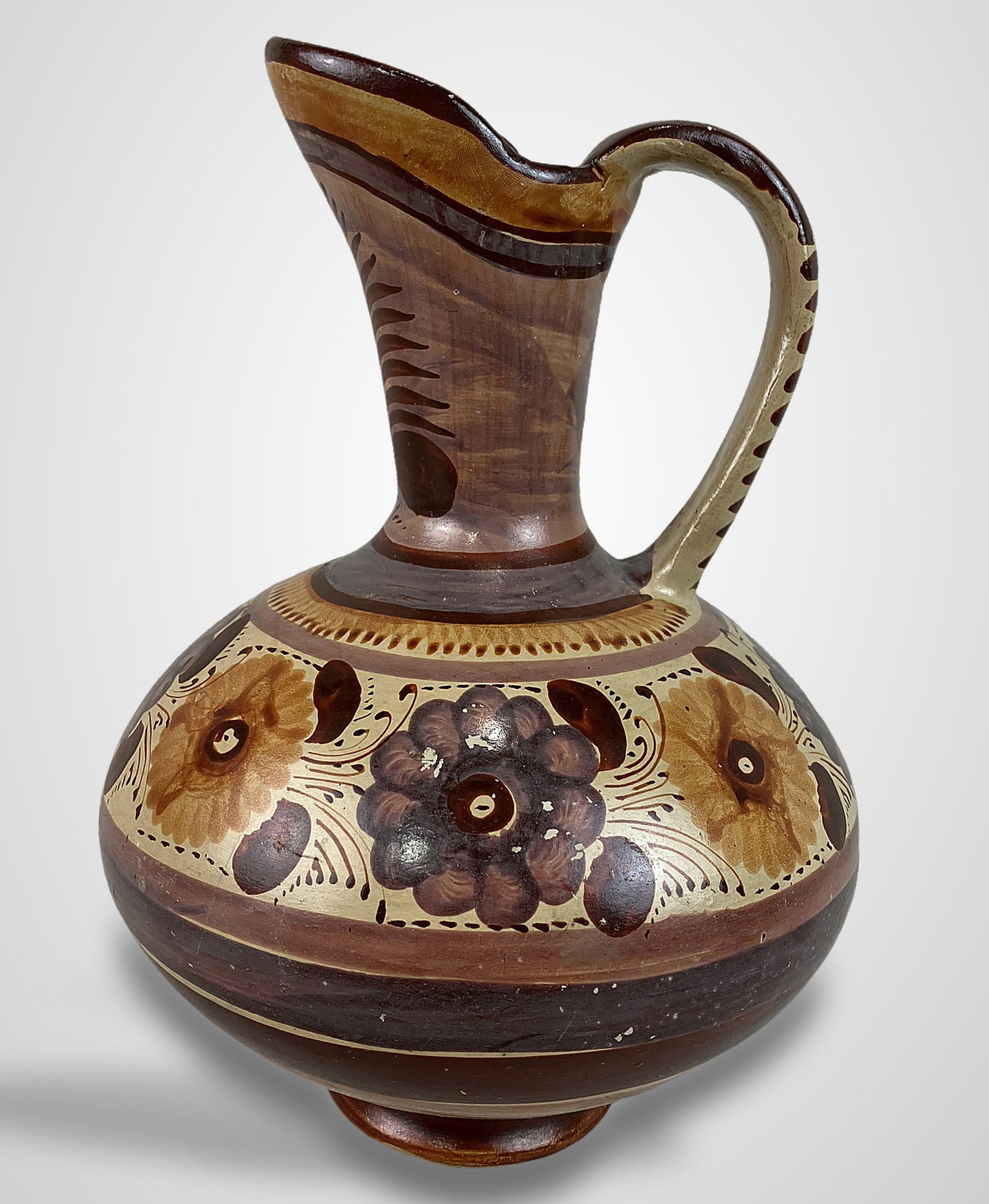 Mexican Folk Art Decorated Pitcher: Clay pitcher, crafted in the tradition of the TonalÃ¡ region, features a rounded belly and a graceful, slender neck with a curving handle. The piece is finished with a hand-burnished,