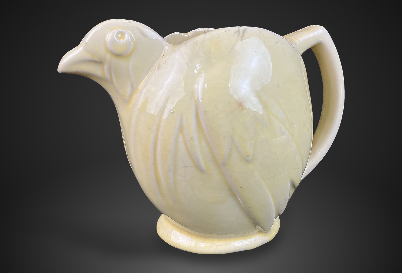 McCoy Pottery Yellow Chicken Pitcher: Charming vintage pitcher features an embossed form resembling a stylized bird, finished in a signature glossy yellow glaze. Produced between the 1940s and 1960s, this piece measures approximately 6 in