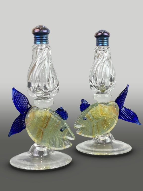 Gazelle Glass Art Glass Fish Salt and Pepper Shakers: This pair of art glass salt and pepper shakers features a tapering form with a twisted, ribbed design that surmounts a tropical fish set on a round base. The fish are detailed with cobalt blue fins