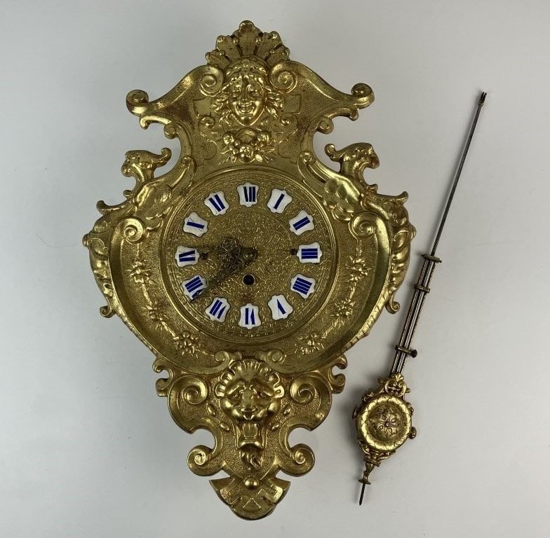 Gustav Becker Brass Ormolu Wall Clock: 19th-century German timepiece by Gustav Becker features a cast brass gilt ormolu surface executed in a Rococo style. The ornate design includes a grotesque lion's mask at the base, a cherub face at