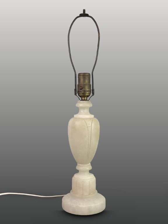 Carved Alabaster Lamp: This lamp features a neoclassical urn-like form decorated with intricate carved designs. It is supported by a fluted, columnar base beneath the curving urn body. The piece measures approximately 13 3/
