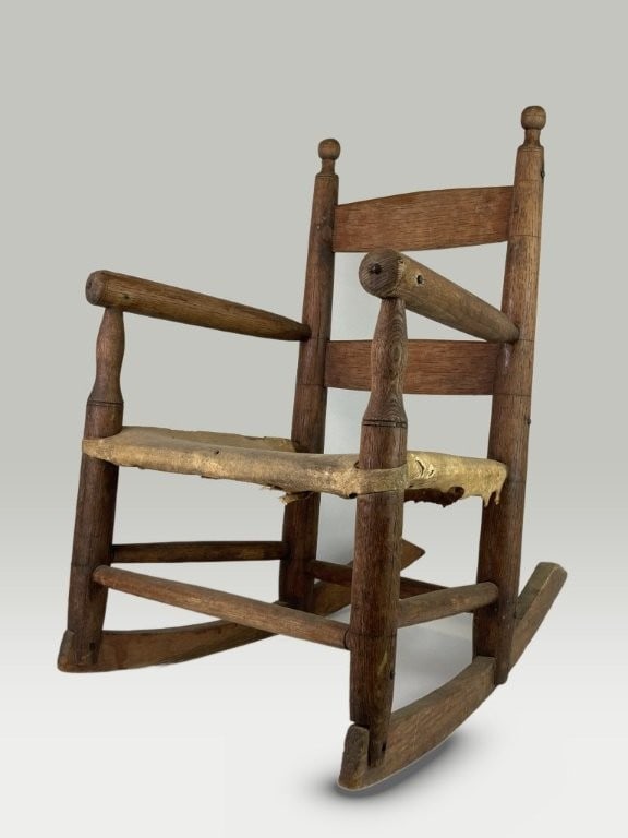 Childrens Country Oak Rocking Chair: Childrens country rocking chair features a sturdy oak construction complete with turned posts and turned finials, complemented by a fine hide seat. The piece measures approximately 20 1/2 in. H x 13